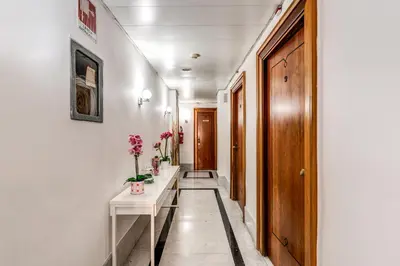 a hallway with a white table and flowers on it at Hotel Max in Rome