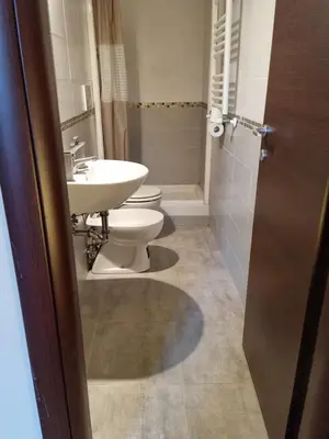 a bathroom with two toilets and a sink at Hostel Mosaic in Rome