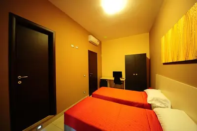a bedroom with two beds and a black door at Hotel Mosaic Central Rome in Rome