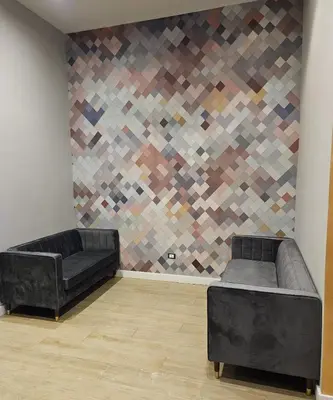 a living room with two black couches and a wall at Hotel Mosaic Central Rome in Rome