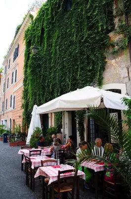 a group of people sitting at tables under an umbrella at Little Rhome Suites in Rome