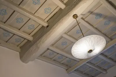 a white light hanging from a ceiling with blue tiles at B&B La Scalinatella in Rome