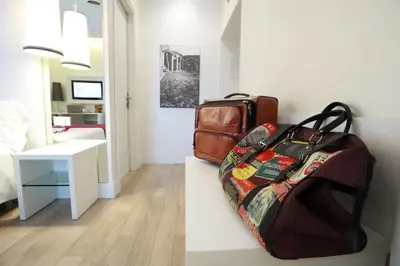 a room with two bags of luggage sitting on a shelf at Tullia&Prisca Relais in Rome
