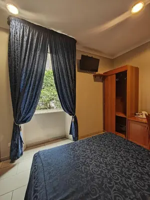 a bedroom with a bed and a window at Domus Roxy in Rome