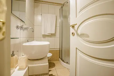 a white bathroom with a sink and a shower at Casa Riz in Rome
