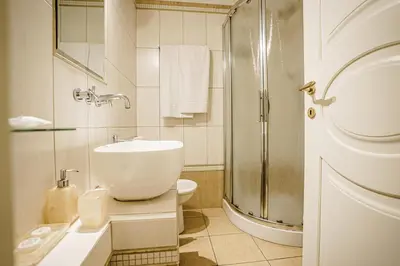 a white bathroom with a sink and a shower at Casa Riz in Rome