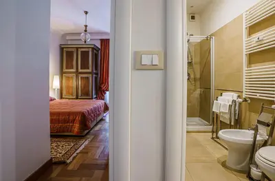 a bathroom with a bed a toilet and a sink at Casa Riz in Rome