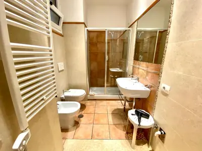 a bathroom with two sinks and a toilet and a shower at SWEETSUITE Rome in Rome