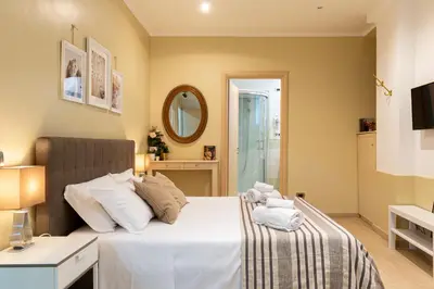 a bedroom with a large white bed and a mirror at Next Stop St Peter Rome in Rome