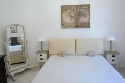 a bedroom with a white bed and a mirror at Aquarius Inn in Rome
