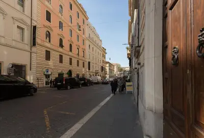 two people walking down a city street with buildings at Quality in Rome in Rome