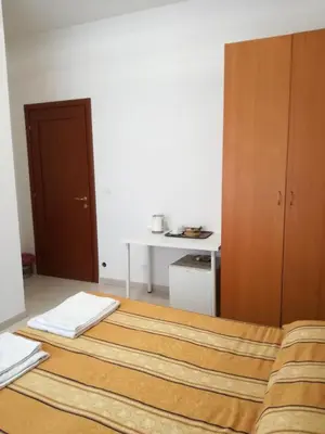 a bedroom with two beds and a cabinet and a desk at Testa Gioacchino B&B in Rome