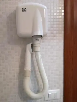 a white phone hanging on a wall in a bathroom at Testa Gioacchino B&B in Rome