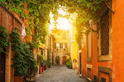 an alley in an old town with the sun shining at Casina Tiberina in Rome