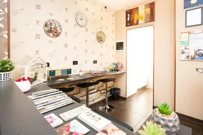 a room with a counter and a desk with a clock on the wall at Eritrea Suite in Rome