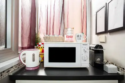a microwave sitting on top of a black counter at Eritrea Suite in Rome