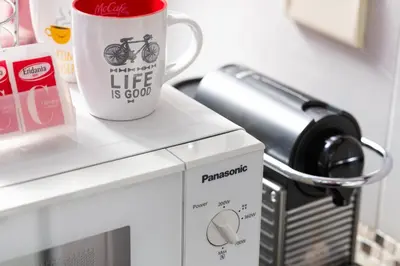 a coffee cup sitting on top of a microwave at Eritrea Suite in Rome