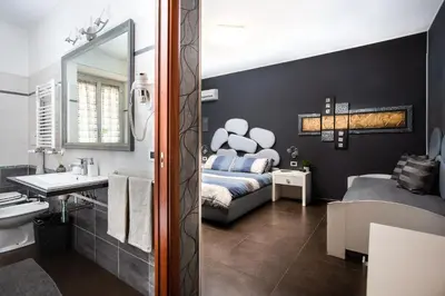 a bathroom with a bed and a bathroom with a mirror at Eritrea Suite in Rome