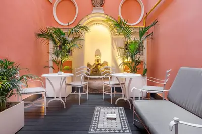 a restaurant with tables and chairs and a statue at DOM Hotel Roma - Preferred Hotels & Resorts in Rome