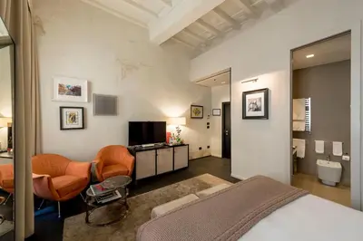 a bedroom with a bed and a living room at DOM Hotel Roma - Preferred Hotels & Resorts in Rome