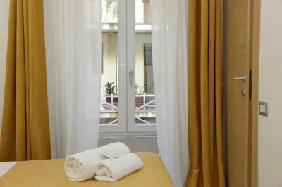two towels sitting on a bed in front of a window at Dream City Rome in Rome