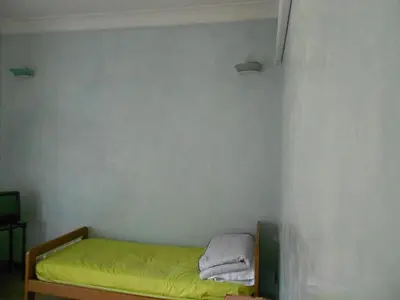 a small room with a bed with yellow sheets and towels at Sidereus in Rome