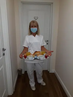 a woman in a mask holding a tray of food at Freedom Love B&B in Rome