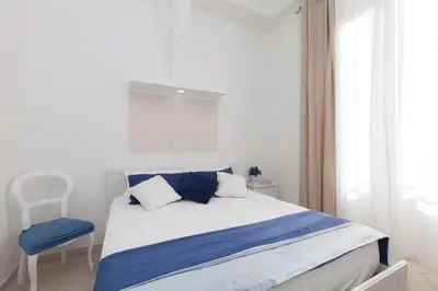 a bedroom with a bed and a blue chair at San Peter Angels in Rome