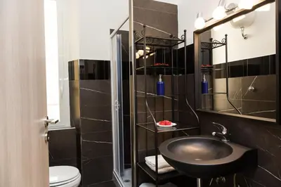 a black bathroom with a sink and a toilet at San Peter Angels in Rome