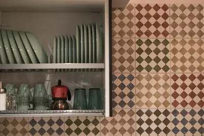 a cabinet filled with green plates and bowls at San Lorenzo 42 in Rome