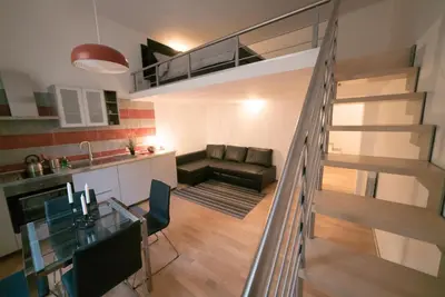 a kitchen and a living room with a staircase in a loft at San Lorenzo 42 in Rome