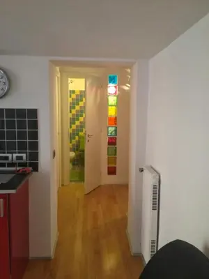 a room with a kitchen and a door with a window at San Lorenzo 42 in Rome