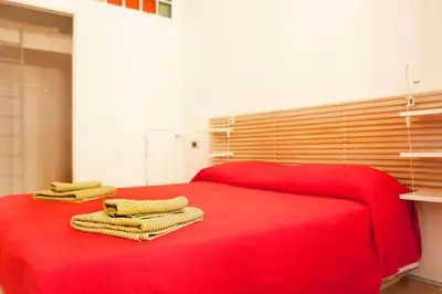 a red bed with two towels on top of it at San Lorenzo 42 in Rome