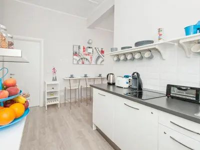 a white kitchen with a bowl of fruit on the counter at White Rooms Colosseo in Rome