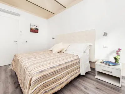 a bedroom with a large bed in a white room at White Rooms Colosseo in Rome