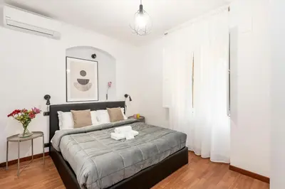 a bedroom with a large bed with white walls at White Rooms Colosseo in Rome