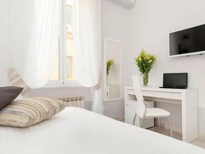 a white bedroom with a white desk and a bed at White Rooms Colosseo in Rome