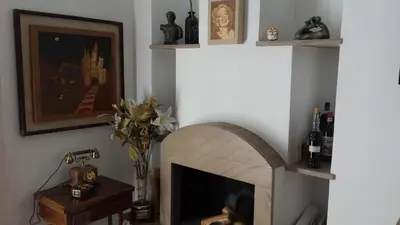a living room with a stone fireplace with shelves at St. John Villa in Rome