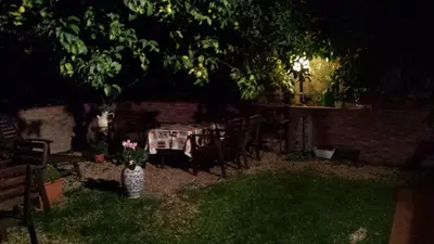 a garden at night with a table and chairs at St. John Villa in Rome