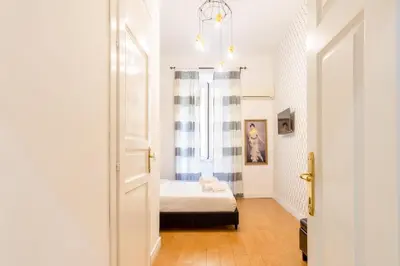 a bedroom with a bed with a black headboard and curtains at Ciao Bella Apartment in Rome