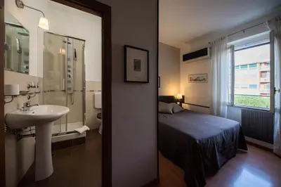 a bathroom with a bed and a sink next to a window at Domus Appia 154 B&B in Rome