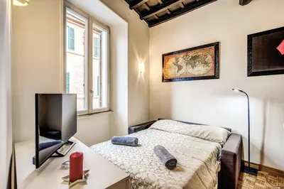 a bedroom with a bed and a flat screen tv at Casa Monticelli in Rome