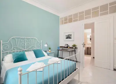a bedroom with a blue bed and a bathroom at Locanderia Roma in Rome