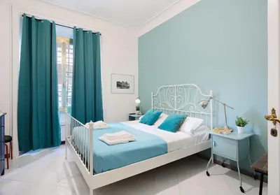 a blue bedroom with a bed and green curtains at Locanderia Roma in Rome