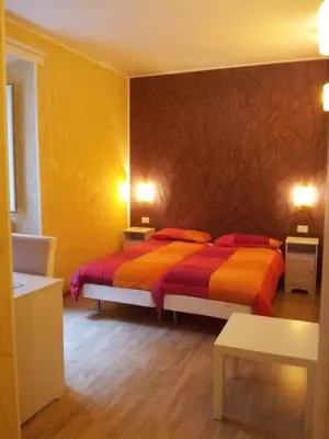 a bedroom with two beds with orange and red sheets at B&B In Piazza in Rome
