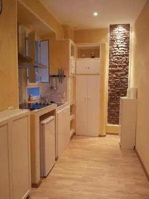 a kitchen with white cabinets and a stone wall at B&B In Piazza in Rome