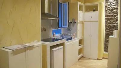 a kitchen with white cabinets and a white refrigerator at B&B In Piazza in Rome