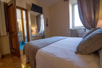 a bedroom with a large bed and a window at Bed & Breakfast A Casa di Lia a Roma in Rome