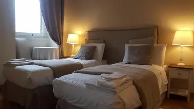 two beds in a hotel room with two lamps at Bed & Breakfast A Casa di Lia a Roma in Rome