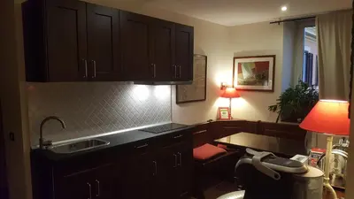 a kitchen with black cabinets and a sink and a table at Bed & Breakfast A Casa di Lia a Roma in Rome